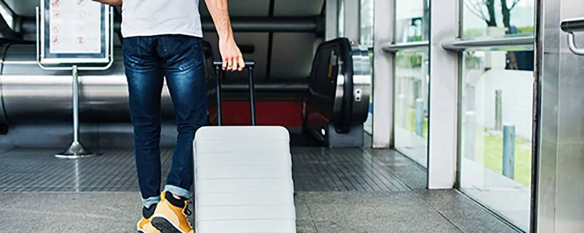brantford home buying specialist walking into airport with his suticase as he prepares to head for vacation