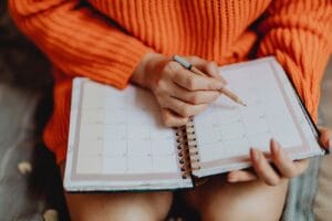 woman making a checklist on a pad of paper about things to do before you move